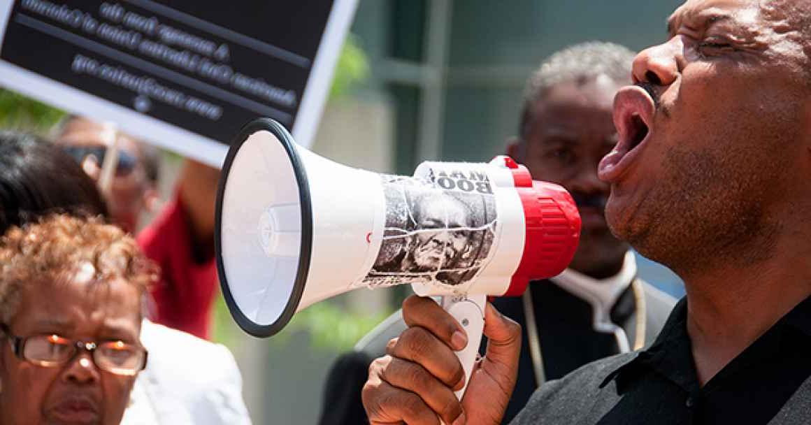 一名男子拿着扩音器参加种族正义抗议活动